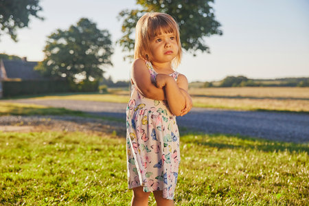 sad child in a sundress in Denmark at sunsetの写真素材