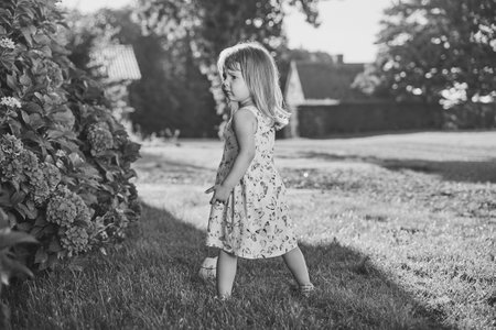 Retro photo of a sad child in a sundress in the suburbsの写真素材