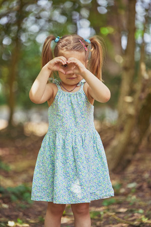 charming child in sundress playing in the yard in the suburbsの写真素材