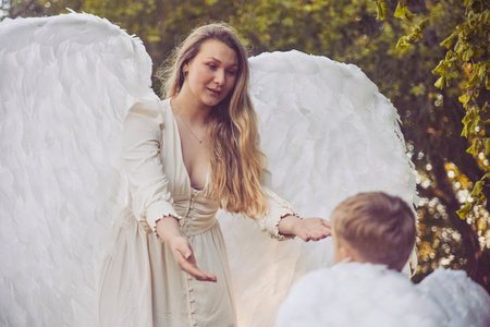 Olstrup, Denmark, June 6, 2023: Girl angel with her son in the gardenのeditorial素材