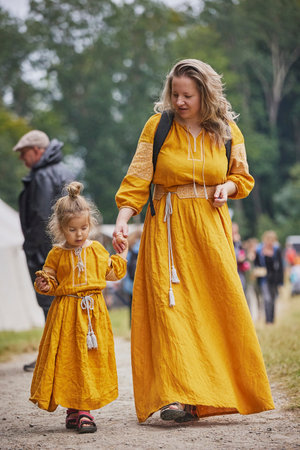 Beautiful woman with her daughter dressed in embroidered dresses