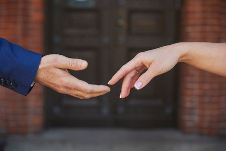 A couple in love reaches out to each other with their handsの写真素材