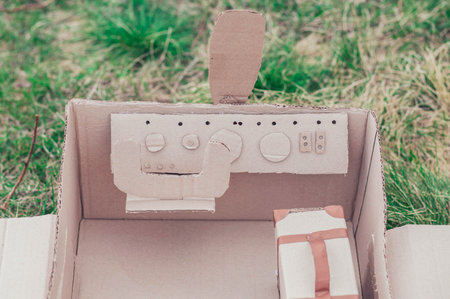 Toy cardboard plane in the field. Focus on the steering wheelの写真素材