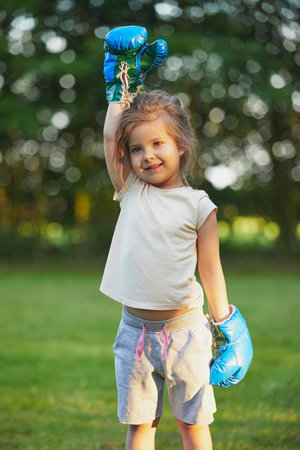 Charming child doing boxing in the backyard on the Sunsetの写真素材