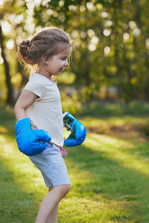 Charming child doing boxing in the backyard on the Sunsetの写真素材