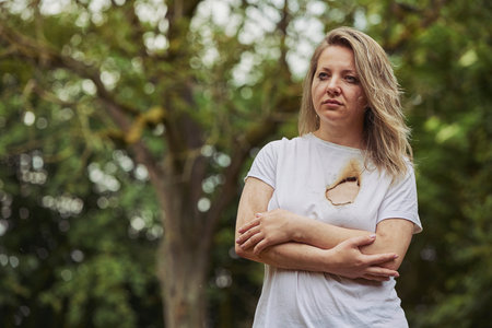 Crying woman with a burnt hole in her heartの写真素材