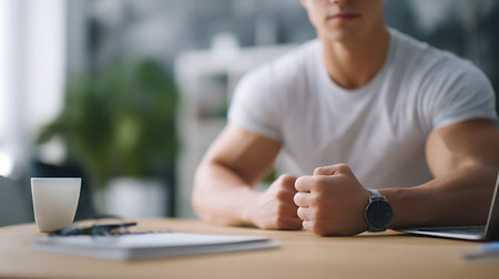 cropped shot of man in white t-shirt using laptop at workplaceの素材