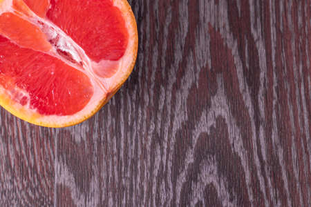 Half grapefruit on wooden surface close upの写真素材