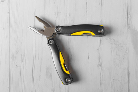 metal multi-tool with pliers on a wooden background