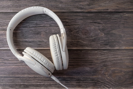 White headphones on a dark wooden background.の写真素材