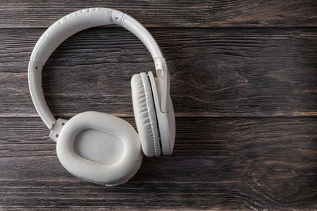 White headphones on a dark wooden background.の写真素材