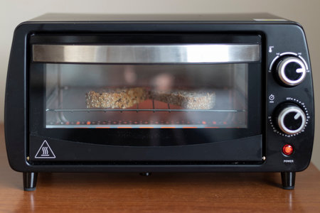 MAKING BREAKFAST TOASTS IN AN ELECTRIC OVENの写真素材