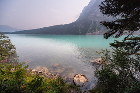 Lake Louise Turquoise Water Mirror Surface with Canadian Rocky Mountains Behind, Summer Day Haze, Banff National Park, Alberta, Canadaの写真素材