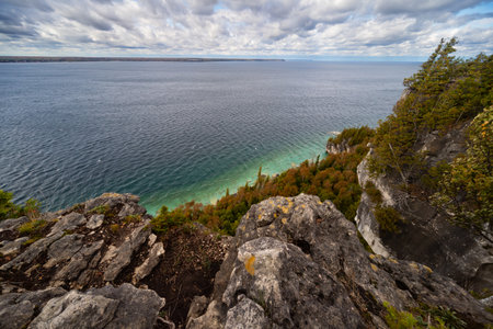 Lake Huron turquoise waterfront surrounded by Limestone Rocky Cliffs with Trees, autumn day landscape, top viewの写真素材