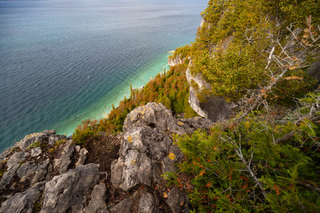 Lake Huron turquoise waterfront surrounded by Limestone Rocky Cliffs with Trees, autumn day landscape, top viewの写真素材