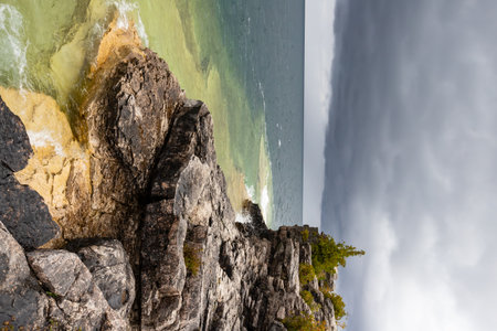 Rugged Rocky Limestone Cliff Surrounded by Turquoise Water of Lake Huron. Stormy Autumn Day near Cyprus Lake, Ontario, Canadaの写真素材