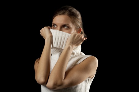 Beautiful young woman looking up into the corner, covering her face collar - isolated on whiteの写真素材
