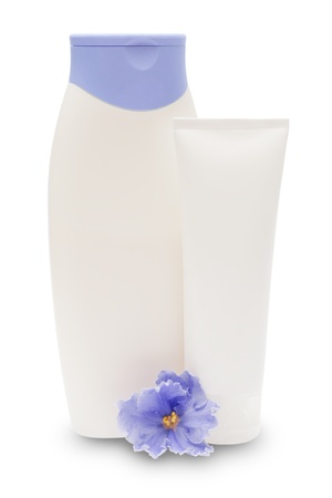 Cosmetic bottles and blue flower isolated on white の写真素材