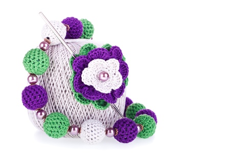 Grey ball of cotton knitting yarn with crochet, knitted flower and necklace on the white backgroundの写真素材