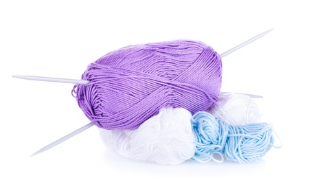 Skeins of violet, blue, white yarn and needles on the white background 