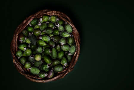 Ripe fresh green Feijoa berries on a dark colored background. contrast of color and shape. Selective focus. Horizontal Top View of Organic Food Healthcare.の写真素材