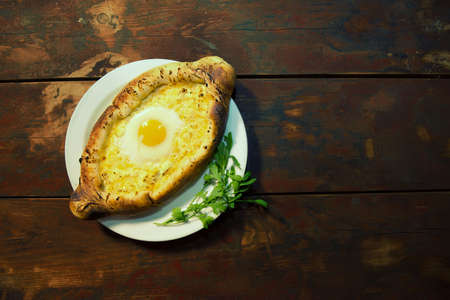 Adjarian khachapuri. Open tarts with mozzarella and egg. Georgian cuisine. Adjarian khachapuri on a...