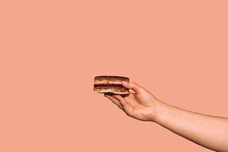Healthy dessert-cake on a pink background with a female hand-modern summer food of a minimalistic concept, copying the space. The concept of a cafe or bakery with desserts.の写真素材