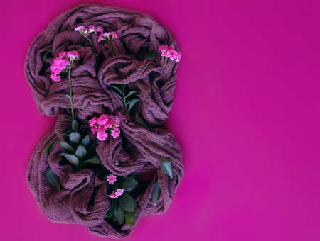 International Women's Day. Banner, flyer, beautiful postcard for March 8. Flowers in combination with textiles in the shape of a figure of eight on a pink background.の写真素材