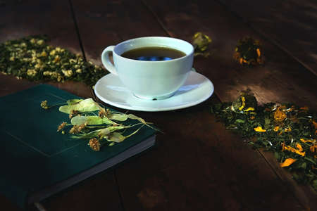 herbal tea in a cup, dried lavender flowers on a book, a scattering of herbal tea and dried flowers...
