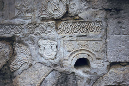 Ancient sculpture and rock engraving on the walls of an abandoned temple in the Caucasus mountains. decorative background for projects. the message of the ancestors to the future. the breath of time.の写真素材