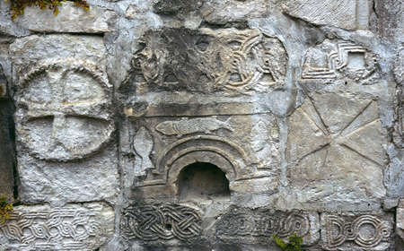 Ancient sculpture and rock engraving on the walls of an abandoned temple in the Caucasus mountains. decorative background for projects. the message of the ancestors to the future. the breath of time.の写真素材