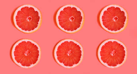 Slices of delicious grapefruit on a bright background, lying flat. fruit slices on a light background, contrasting background that attracts attention.advertising for a cooking blog. bright juicy colorsの写真素材