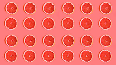 Slices of delicious grapefruit on a bright background, lying flat. fruit slices on a light background, contrasting background that attracts attention.advertising for a cooking blog. bright juicy colorsの写真素材
