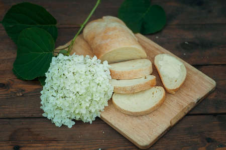 homemade bread, sliced on a wooden board. On a dark background with decorative elements. soft...