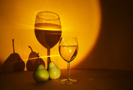 a glass of white wine on a bright background, exclusive design and development of advertising of alcoholic beverages. the play of chiaroscuro increases the attention to alcoholic beveragesの写真素材