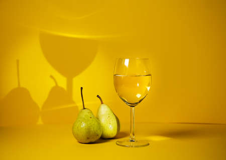 a glass of white wine on a bright background, exclusive design and development of advertising of alcoholic beverages. the play of chiaroscuro increases the attention to alcoholic beveragesの写真素材