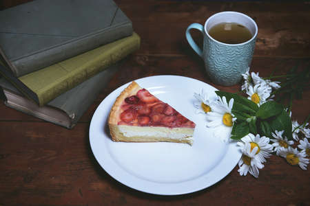 Strawberry cheesecake close-up on a plate. photo in a rustic style. the concept of comfort and home atmosphere. photos for social networks and a personal culinary blog. inspiration.の写真素材