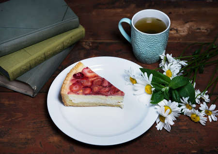 Strawberry cheesecake close-up on a plate. photo in a rustic style. the concept of comfort and home atmosphere. photos for social networks and a culinary blog. advertising of a home confectionery.の写真素材
