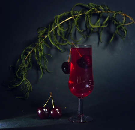 photo of a glass of red wine on a dark background. with space to copy. a stylish composition in advertising. for the presentation of new drinks.advertising of alcoholic beverages. spectacularの写真素材