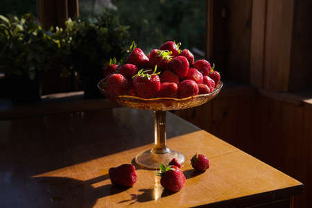 raw organic strawberries in a vintage dish. the concept of comfort and home style. morning in the village, holidays. the interior of the summer veranda. Ripe berriesの写真素材