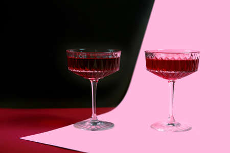 two glasses of red wine on a bright background, a festive and fun concept. advertising of new vintage red wine, American-style parties. poster. copy space. romantic eveningの写真素材