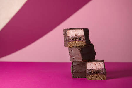 chocolate brownies with lingonberry cream, a layer of mousse and nut praline. on a bright background. advertising of premium confectionery products, a blog with recipes. advertising of consumer loans.の写真素材