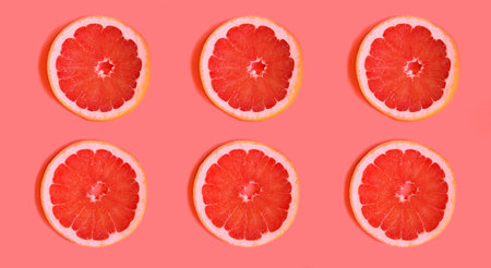 Slices of delicious grapefruit on a bright background,lying flat. fruit slices on a light background, contrasting background that attracts attention.advertising for a cooking blog. bright juicy colorsの写真素材