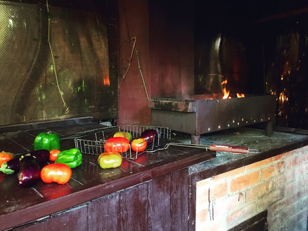 Barbecue, grilled tomatoes, eggplant, chili, garlic halves. Blazing fire, embers and smoke. The concept of cooking. summer kitchen. vegetarianism, the concept of a healthy lifestyle.の写真素材