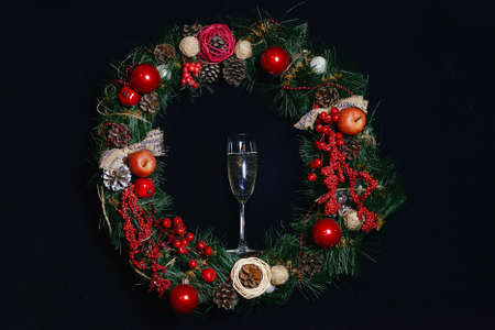 Christmas glass of sparkling wine against the background of a Christmas wreath. Christmas holiday concept. Christmas, New Year's holiday. Selective focus. copy space. New Year card.の写真素材