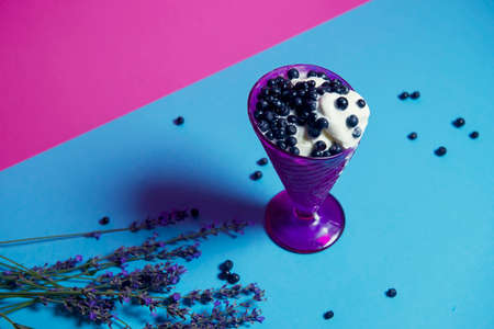 dessert of ice cream in a purple vase with fresh blueberries and lavender sprigs. Dessert for a hot party. isolated object. copy space, advertising - suitable for any field of activity. Vary periの写真素材