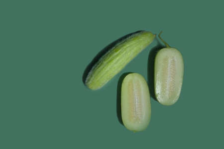 A beautiful green cucumber on a bright background, a vegetable on a colored background, a sliced cucumber on a light green background close-up. copyspace. wonders of choice. hairy cucumber. sexyの写真素材