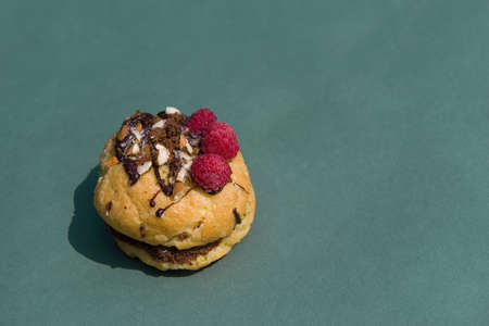 Cupcake Little sizes with raspberries on a green background. summer mood. Confectionery blog, banner in a cafe and a restaurant. Menu of confectionery. Stove at home. A tempting offerの写真素材
