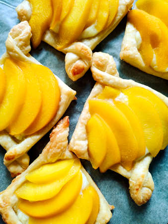 Puff buns with fruit and custard, homemade cakes. we cook at home. buns with peaches on protvin close-up. just out of the oven. soft focusの写真素材