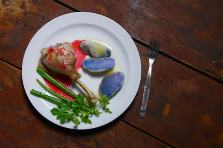 Baked duck thigh with spices and herbs. Barbecue meat. view from above. Exclusive dishes at the restaurant. Duck confit with truffles and lingonberry sauce on a dark table background. copyspace.の写真素材
